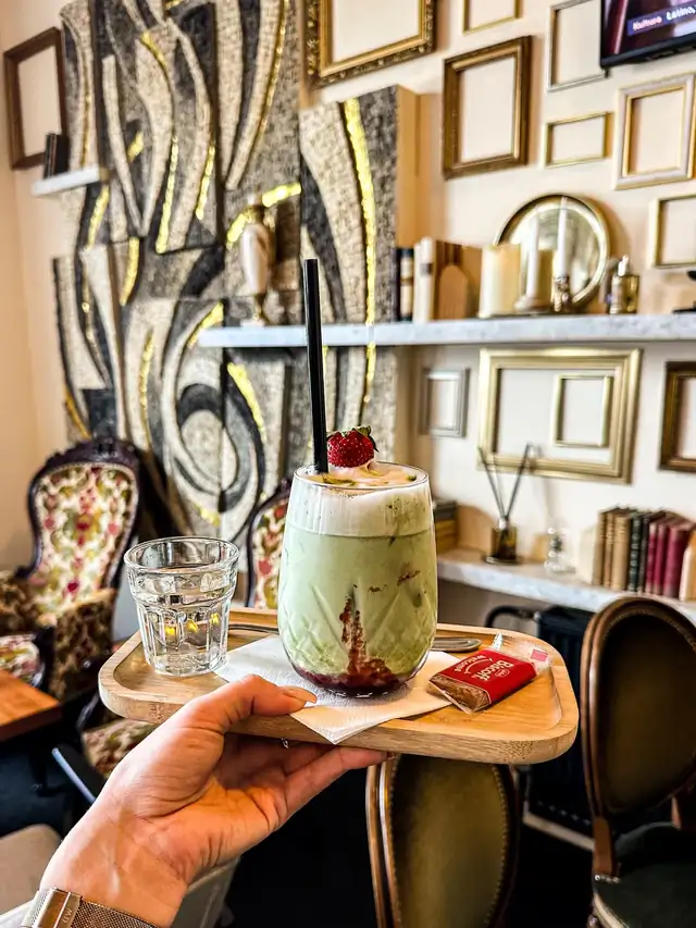 Matcha v interiéru Pia s ozdobnými rámy a útulným posezením